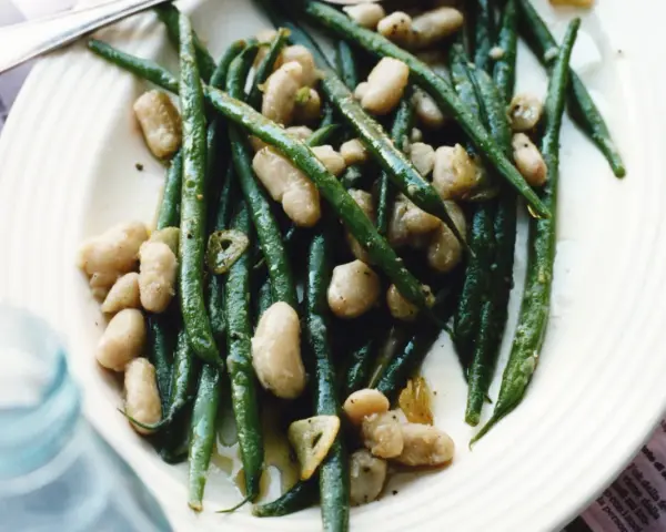 En tallrik med gröna haricots verts och vita bönor, lätt oljade och kryddade. En läcker och enkel rätt.