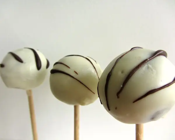 Tre vita cake pops med mörk chokladglasyr, perfekta för ett enkelt cake pops recept.