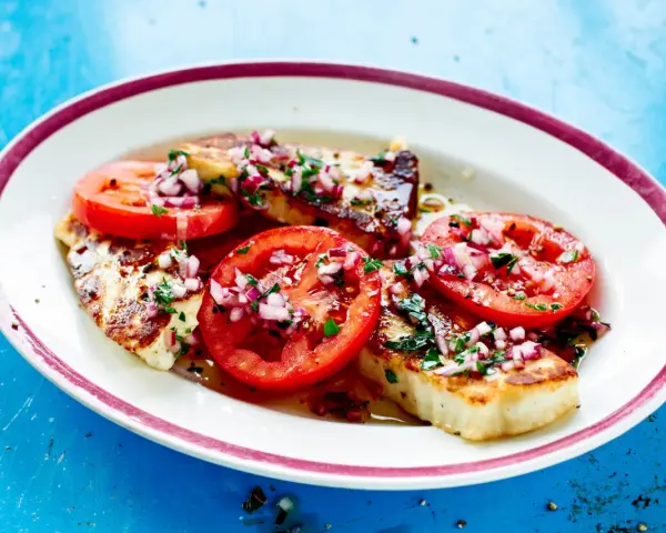 Grillad halloumi med tomater och rödlök, en perfekt sommarrätt. Här är hur grillar man halloumi för bästa resultat.