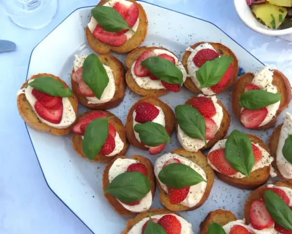 Bruschetta med mozzarella, jordgubbar och basilika. En härlig sommardelikatess som passar perfekt till mingel.