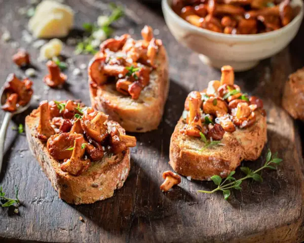 Tre läckra kantarelltoast i ugn, toppade med färska örter och lite ost. En perfekt höstlig delikatess.