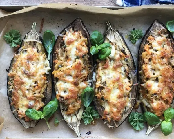 Fyra halverade auberginer fyllda med pasta och ost, ett läckert aubergine recept. Garnerade med färska örter.