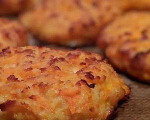 Närbild på gyllene morot halloumi biffar, perfekt stekta med krispiga kanter.