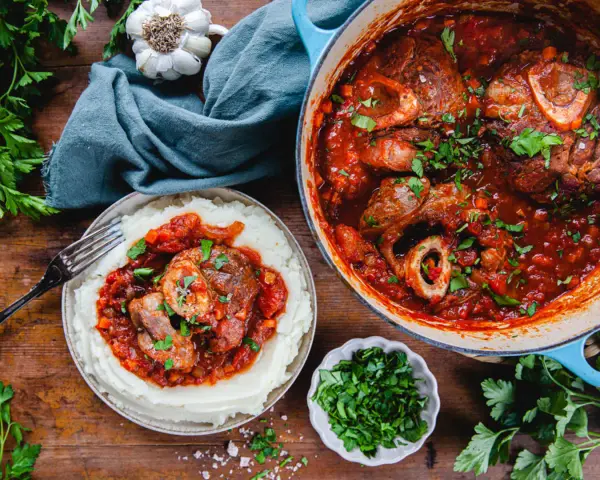 En mustig gryta med osso buco i tomatsås, serverad med krämigt potatismos. Perfekt vin till osso buco!