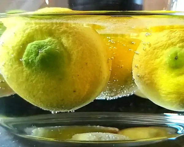 Citroner i en skål med bubblor, redo för ett limoncello recept.