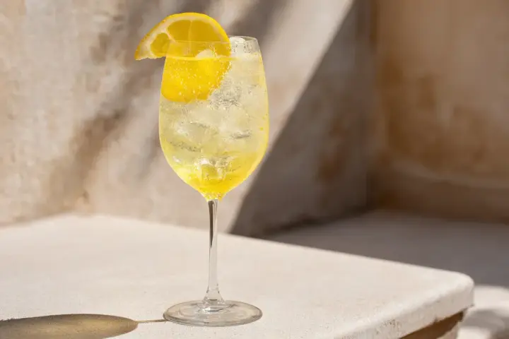 Ett glas med is och en citronskiva, fyllt med en bubblig limoncello spritz.