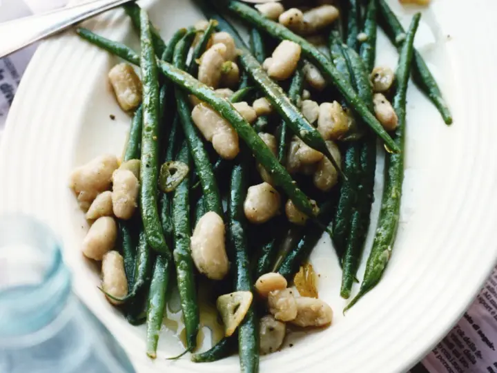 En tallrik med gröna haricots verts och vita bönor, lätt oljade och kryddade. En läcker och enkel rätt.