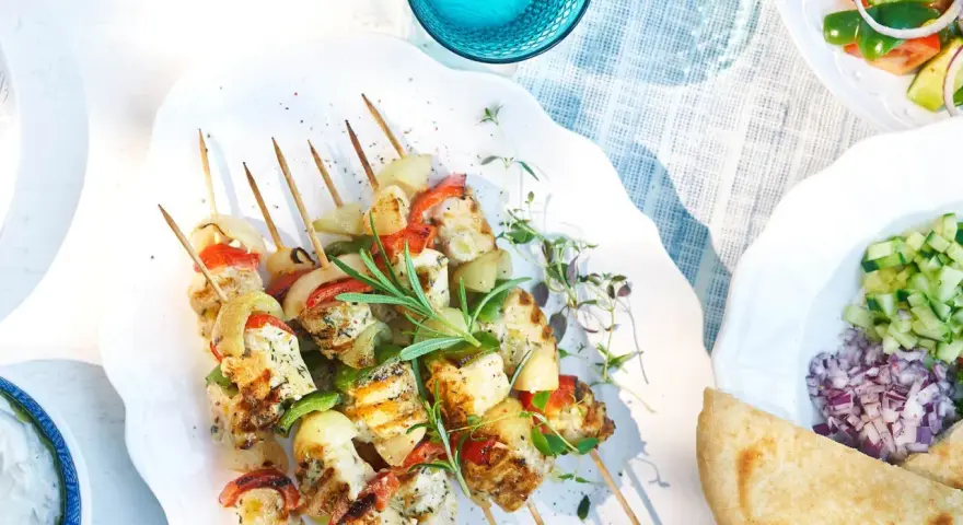 Grillade spett med souvlaki kyckling, grönsaker och örter. Serveras med tzatziki, sallad och pitabröd.