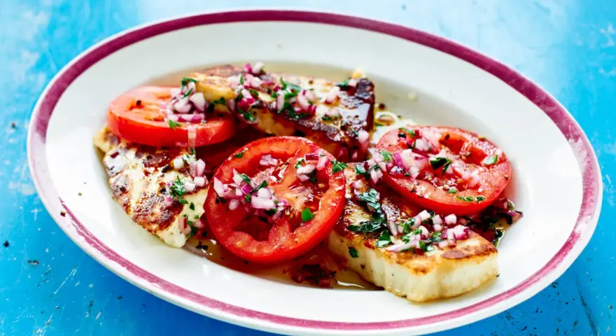 Grillad halloumi med tomater och rödlök, en perfekt sommarrätt. Här är hur grillar man halloumi för bästa resultat.