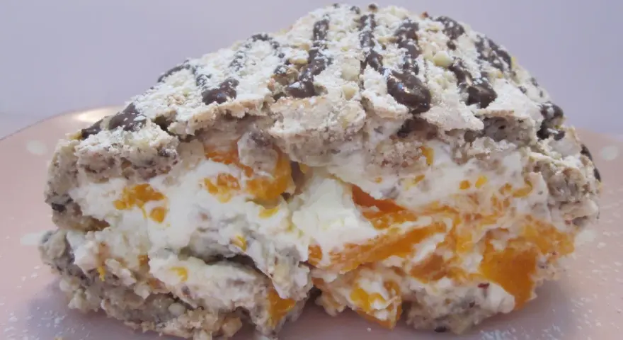 En bit av en Budapestrulle med aprikoser och grädde, toppad med choklad och florsocker. Ett härligt budapestrulle recept!