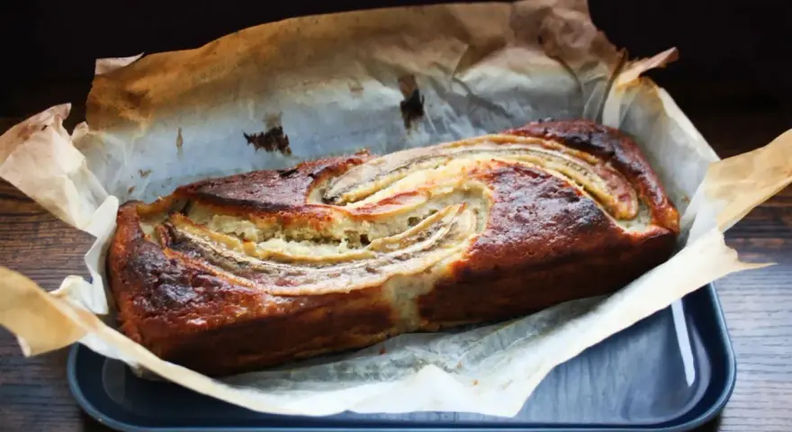 Nybakad banankaka med gyllene skorpa och bananskivor på toppen. Perfekt att baka med banan!