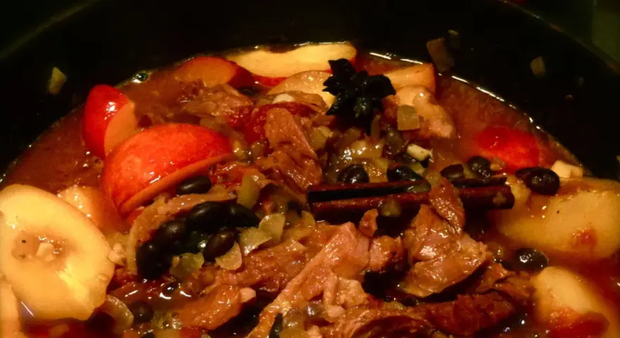 En mustig gryta med kött, äpple och plommon i konjak, kryddad med kanel och stjärnanis.