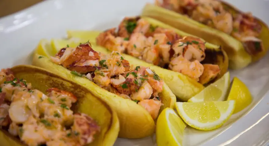 Färska lobster rolls med citronklyftor. Ett perfekt lobster roll recept för en somrig lunch.