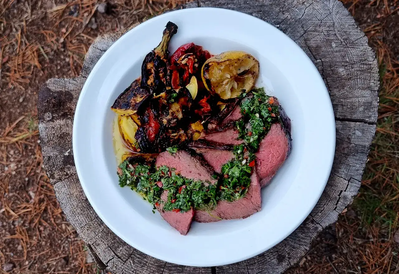 Skivat picanha på en tallrik med grillade grönsaker och citron. Perfekt för en somrig picanha grilla.