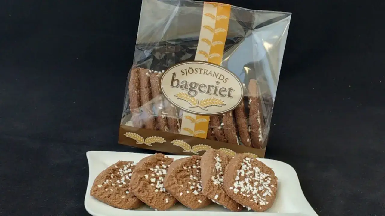 Chokladsnittar recept från Sjöstrands Bageri. Mörka, spröda kakor med pärlsocker på en vit assiett.