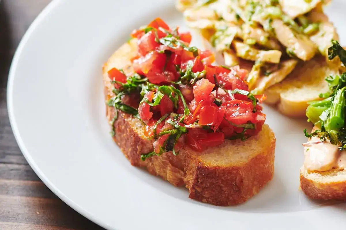 En härlig italiensk bruschetta med färska tomater och basilika. Perfekt för ett enkelt och gott italiensk bruschetta recept.