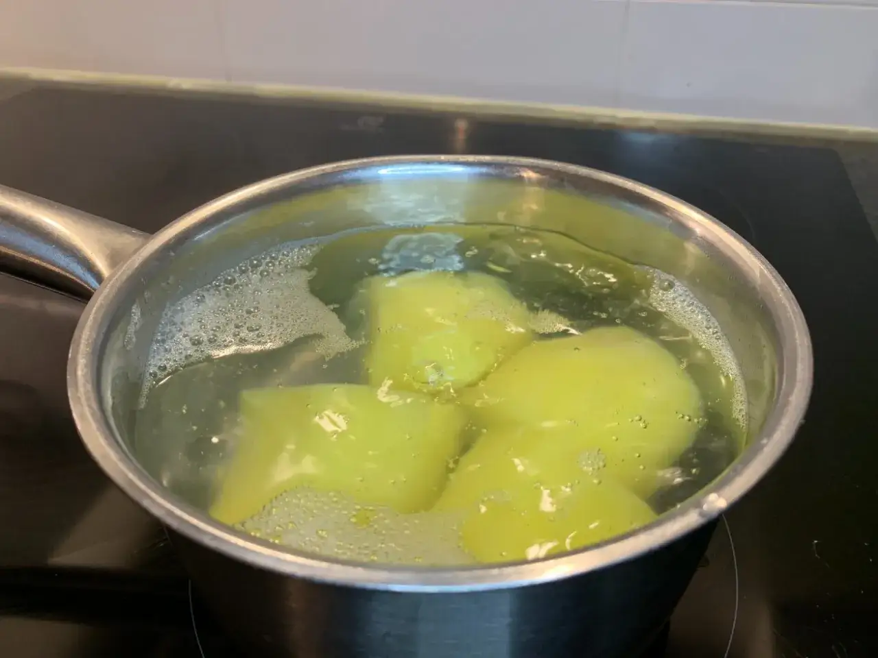 Potatis kokar i en kastrull. Enkel guide f&ouml;r hur kokar man potatis f&ouml;r en god middag.
