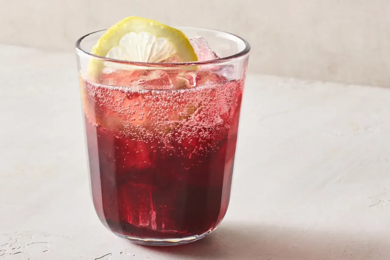 Ett glas med is och en citronskiva fyllt med bubblande tinto de verano.