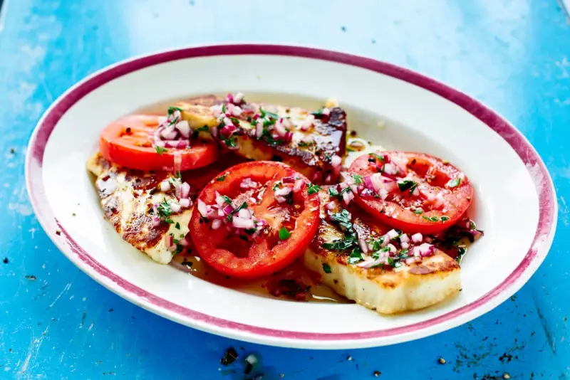 Grillad halloumi med tomater och rödlök, en perfekt sommarrätt. Här är hur grillar man halloumi för bästa resultat.