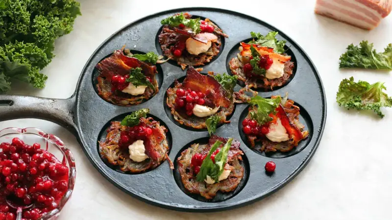 Små rårakor med bacon, gräddfil och lingon i en gjutjärnspanna. Ett härligt recept på rårakor!